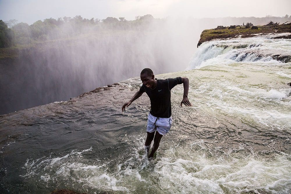 Person jumping at Devils Pools in Zambia
