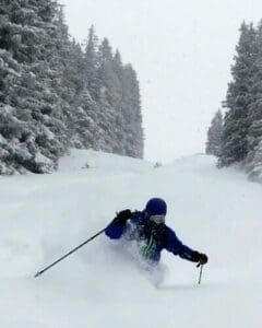 Skier sliding down snow-covered slopes