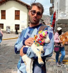 Jon Kortajarena with a baby goat in his arms in Peru