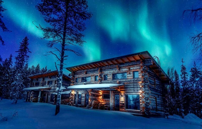 Cabaña de madera en ruka con auroras boreales