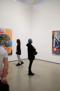 Two women looking at paintings in an art gallery