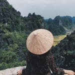 Vista de una mujer con un sombrero frente a las montañas de Vietnam